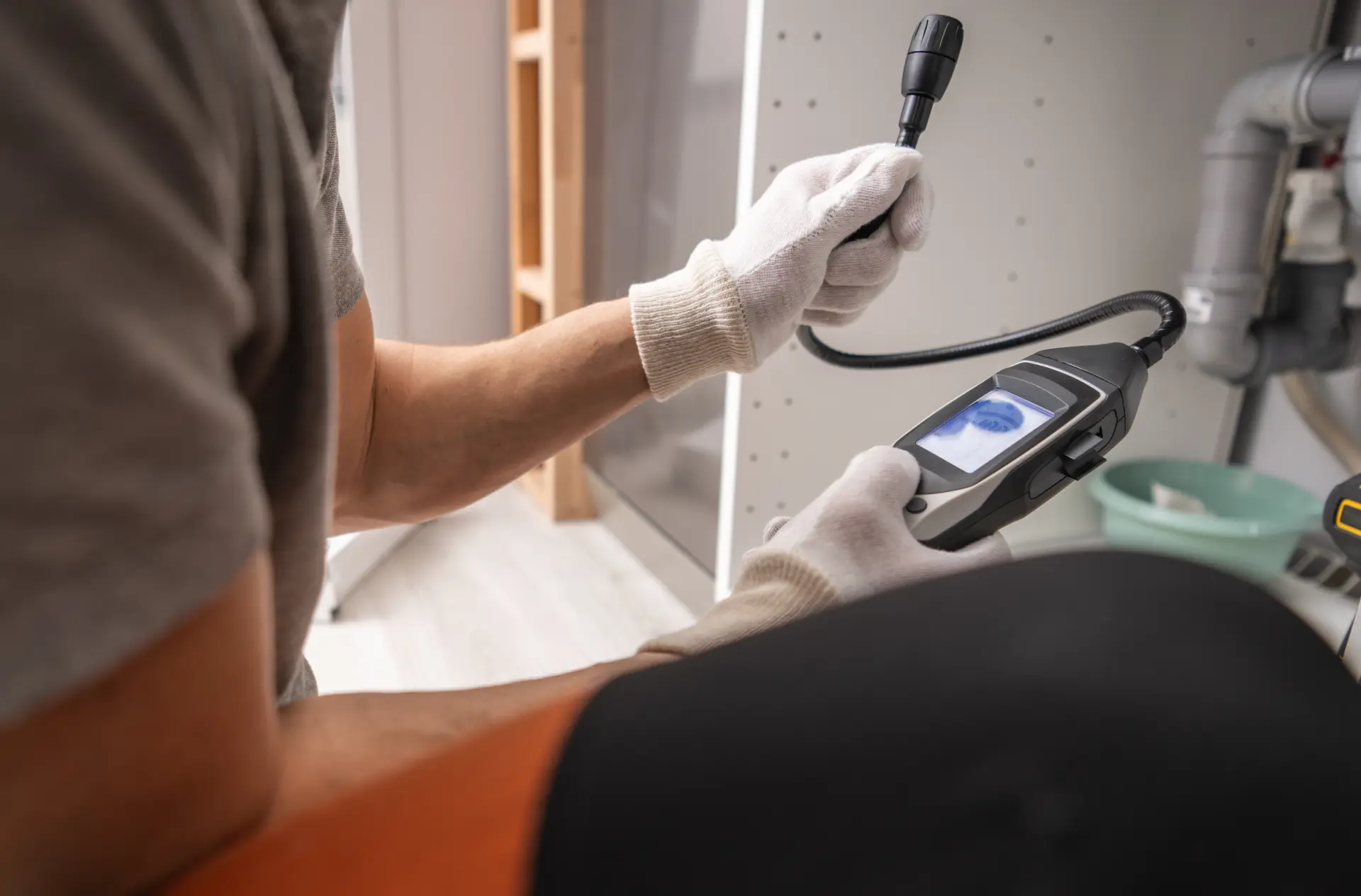 Technik vykonáva diagnostiku úniku plynu v interiéri pomocou digitálneho detekčného zariadenia.