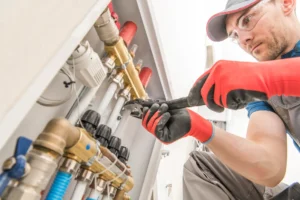 Servisný technik čistí rozvody podlahového kúrenia pomocou profesionálneho náradia