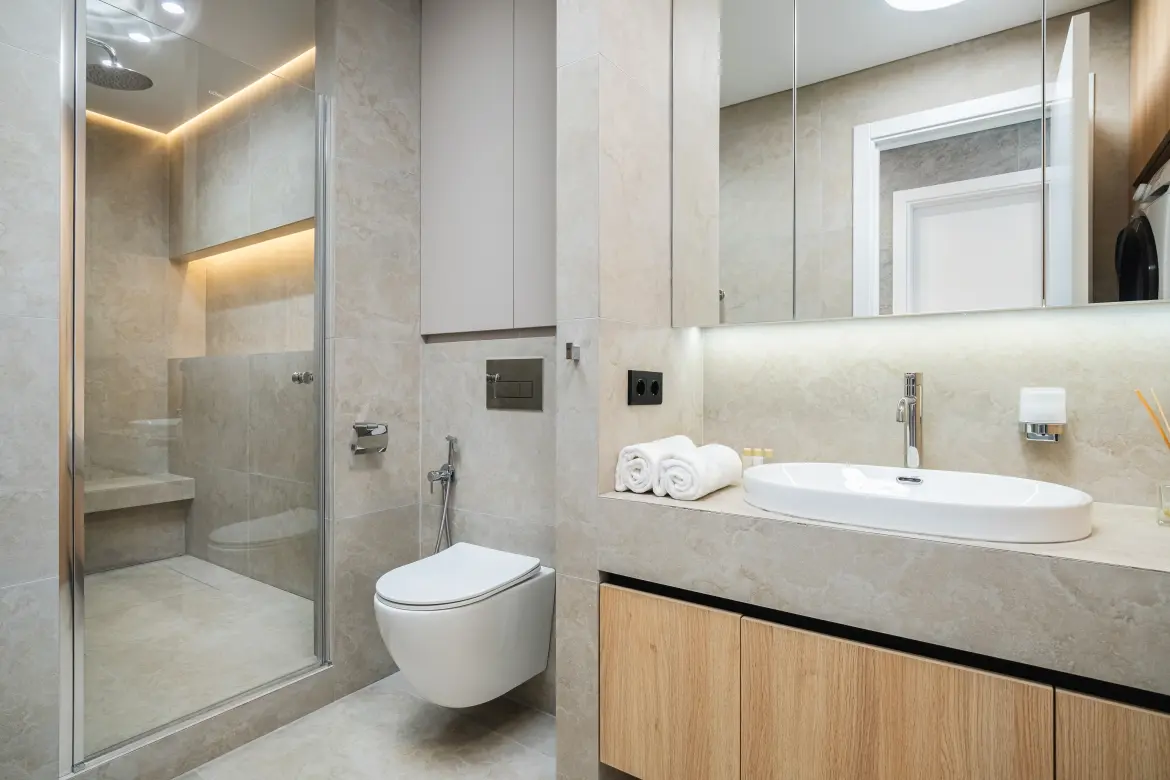 Moderná kúpeľňa po kompletnej rekonštrukcii so sprchovým kútom, závesným WC a elegantným umývadlom.