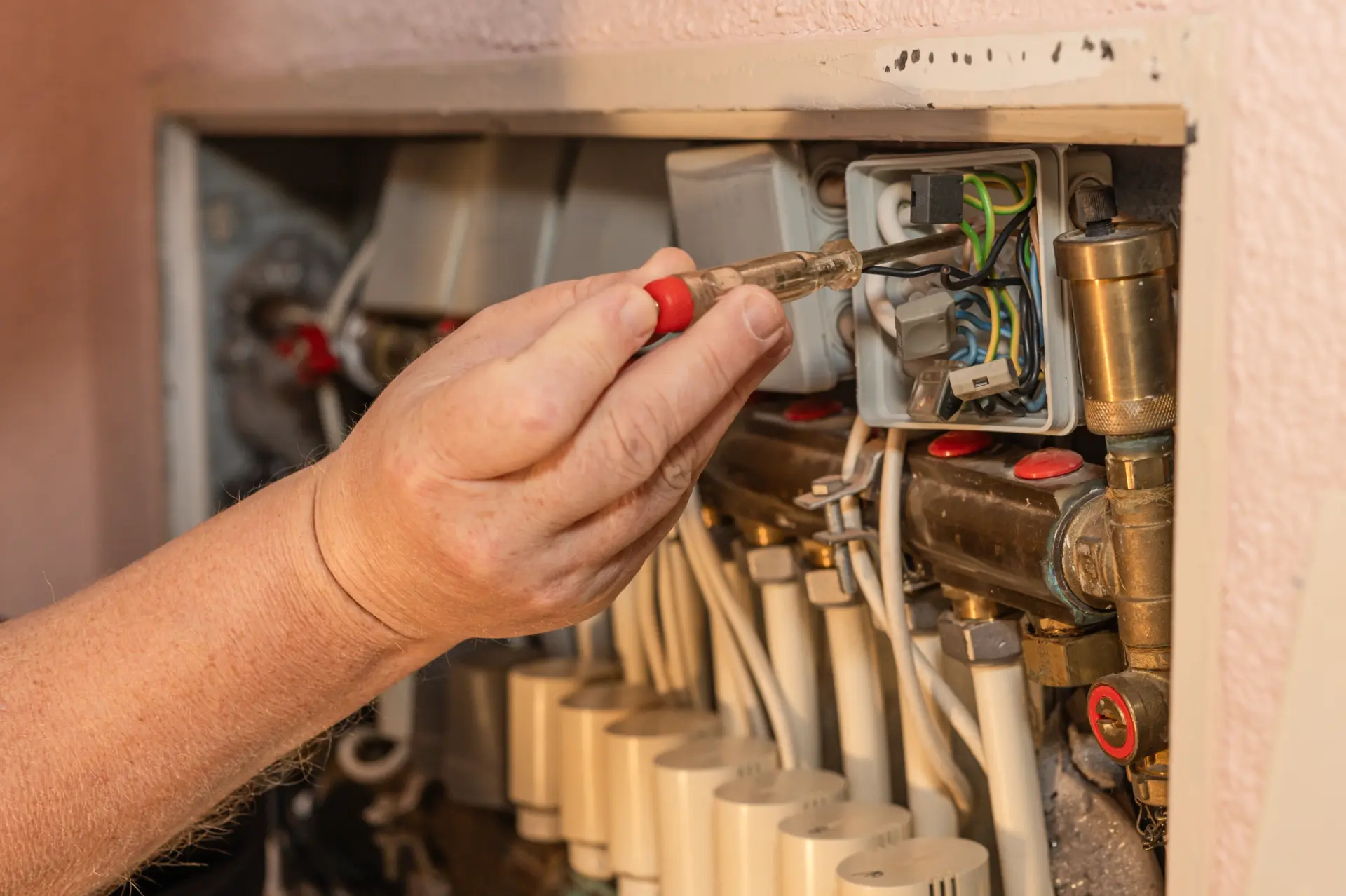 Kontrola elektrického zapojenia v rozdeľovači kúrenia pomocou skúšačky.