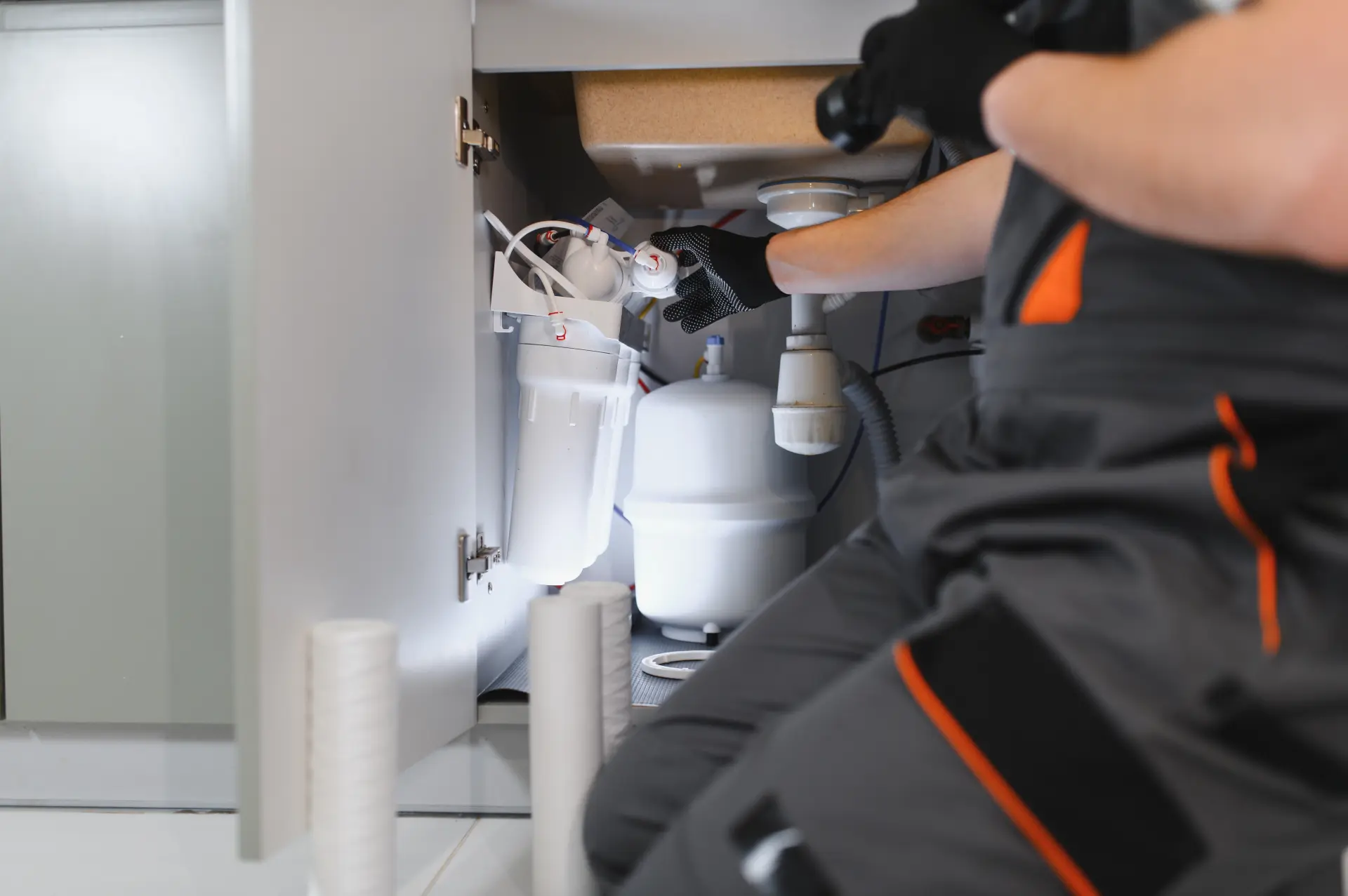 Servis a kontrola vodného filtračného systému pod drezom technikom.