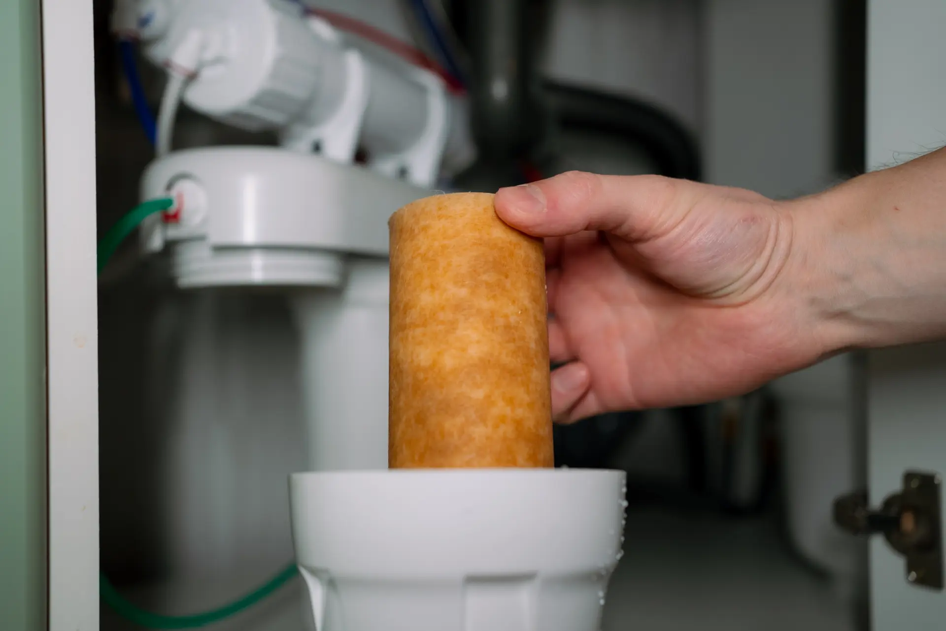 Výmena filtračnej vložky vo vodnom filtri pod kuchynským drezom.