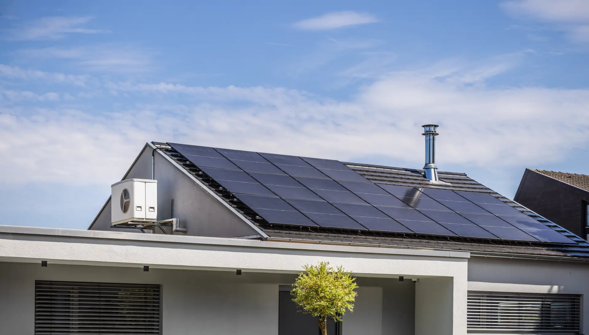 Rodinný dom so solárnymi panelmi na streche na výrobu elektrickej energie z obnoviteľných zdrojov.