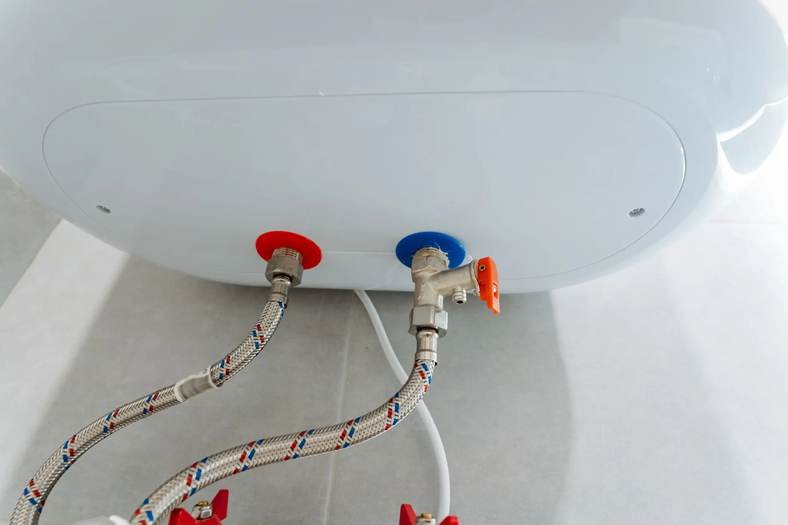 Detail správne pripojeného elektrického bojlera s flexibilnými hadicami, uzatváracím ventilom a rozvodom studenej a teplej vody.